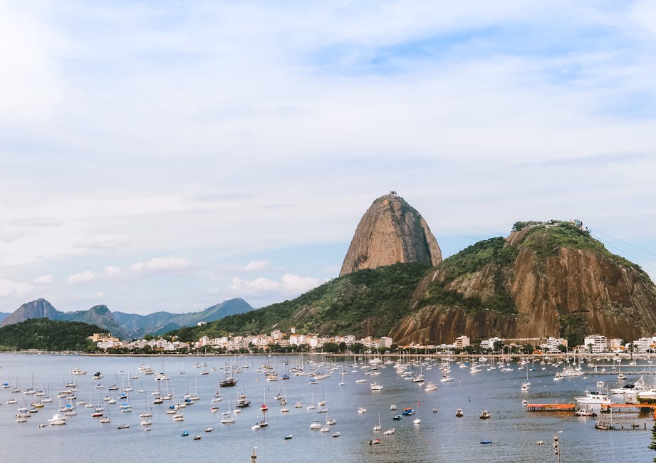 Captivating view of Sugarloaf Mountain in Rio de Janeiro with boats in the bay under a clear sky.  Imagem do Rio de Janeiro para ilustra o artigo QI médio do Brasil 