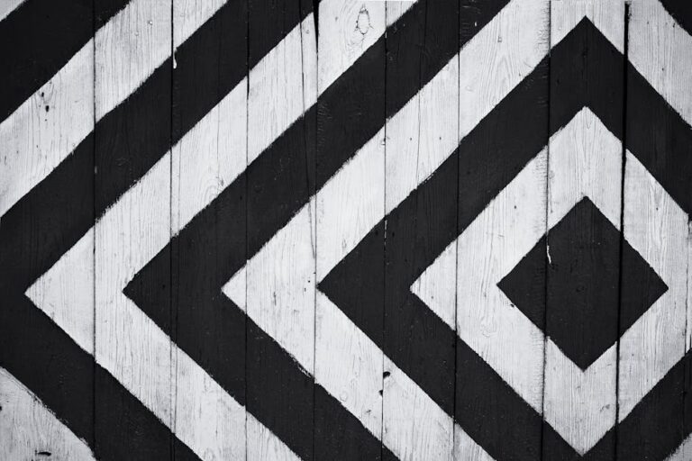 Black and white geometric pattern on wooden planks, ideal for modern design backgrounds.